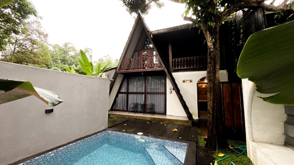 a villa with a swimming pool in front of a house at Patria Villa Turi in Soprayan