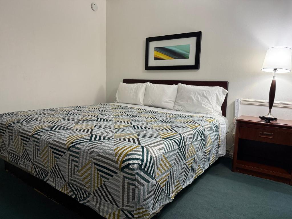 a bedroom with a bed and a lamp on a table at WINDTREE INN in Grove Hill