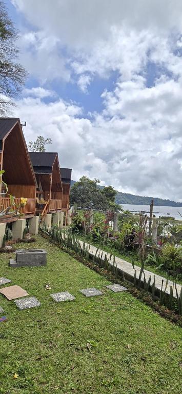 a view of a yard with houses and the water at Teras Danu in Bedugul