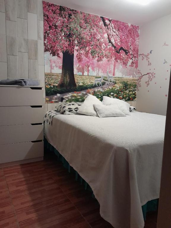 a bedroom with a bed with a painting on the wall at El valle 2 in Copiapó