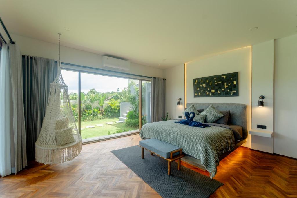 una camera da letto con un letto e una grande finestra di Newly Built Villa - Rice Fields & Tranquil Getaway a Tumbak Bayuh