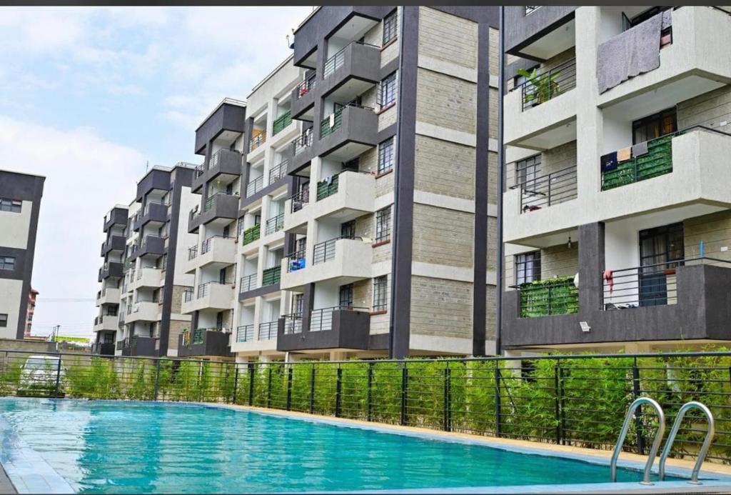 a swimming pool in front of a apartment building at Bliss Homes in Nairobi
