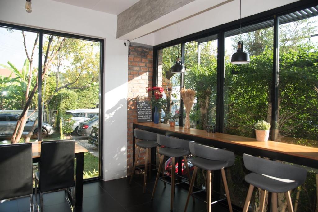 A bright breakfast bar beside full-height windows overlooking greenery and parked cars.