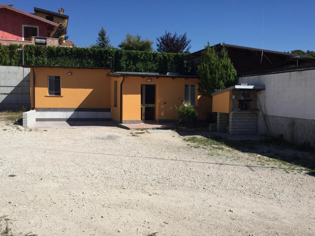 una casa amarilla con hiedra en el techo en casetta dell'Alpino en LʼAquila