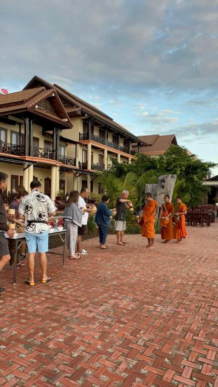 a group of people standing in front of a building at Pon Arena Hotel in Muang Không