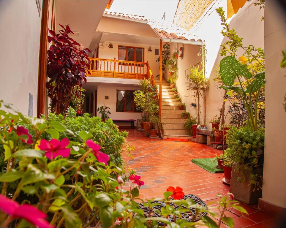 einen Innenhof eines Hauses mit Blumen und Pflanzen in der Unterkunft El Chasqui in Ollantaytambo