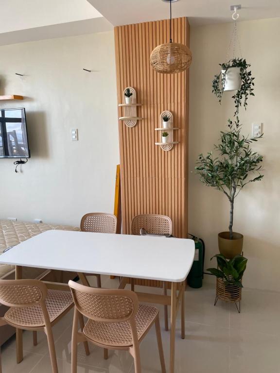a dining room with a white table and chairs at Mactan Plains condo unit in Punta Engaño