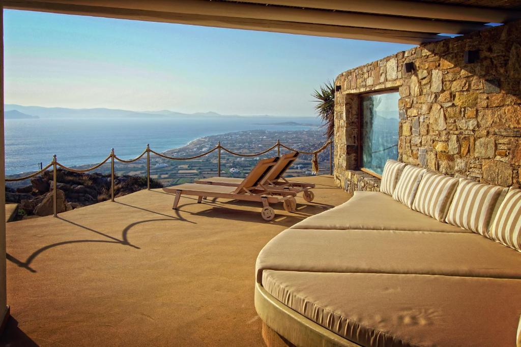 a bedroom with a balcony with a view of the ocean at Villas Naxos Grande Vista in Vívlos