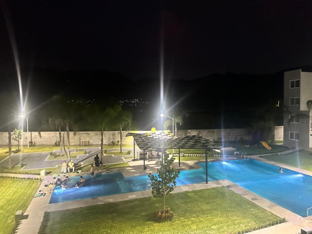 a pool at night with people sitting around it at La Casa de Coco in Oacalco