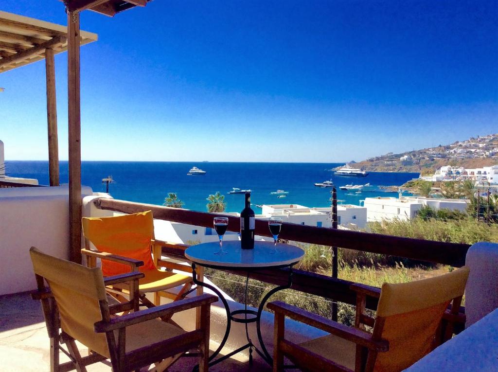 stół i krzesła na balkonie z widokiem na ocean w obiekcie Manos Studios w mieście Platis Gialos Mykonos