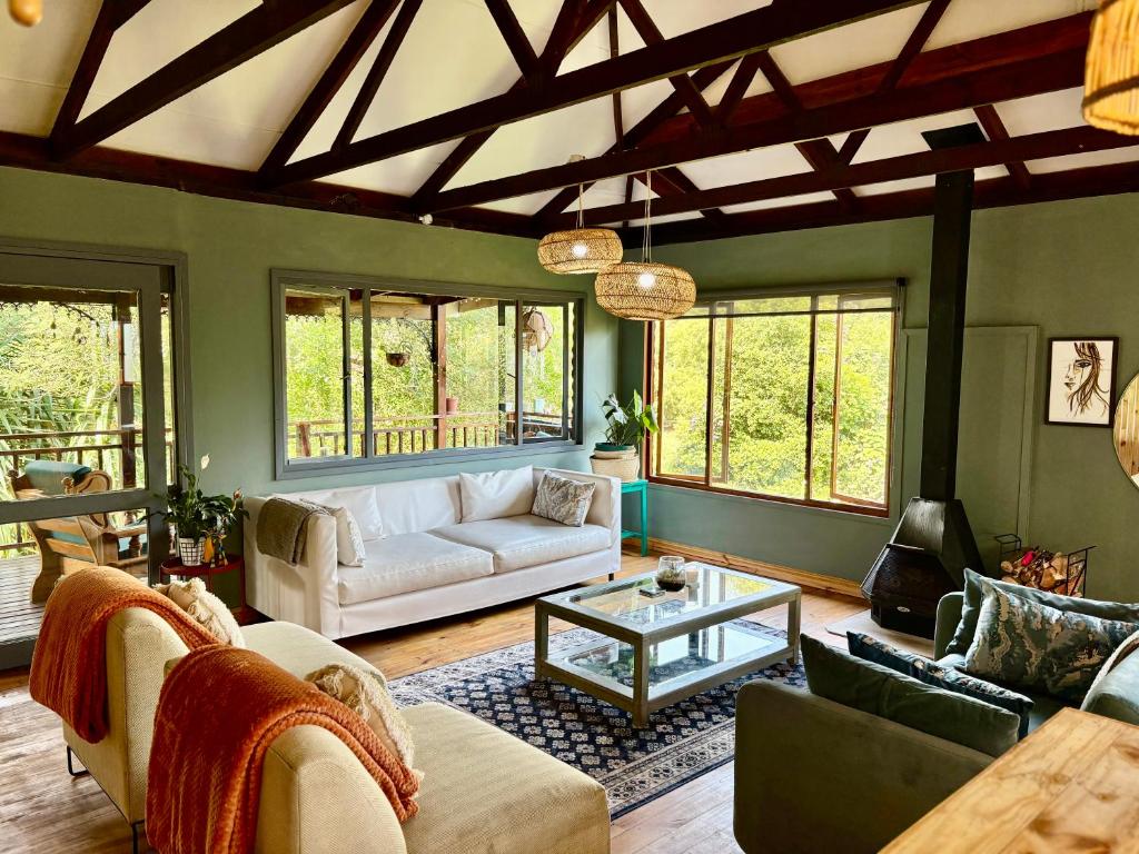 a living room with a couch and a table at Elephant loft in Stormsrivier