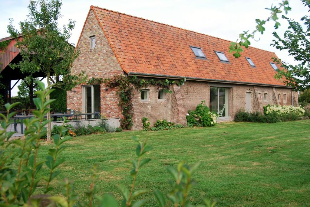 a brick house with an orange roof on a yard at Vakantiehuis Hof te Voorde in Deerlijk