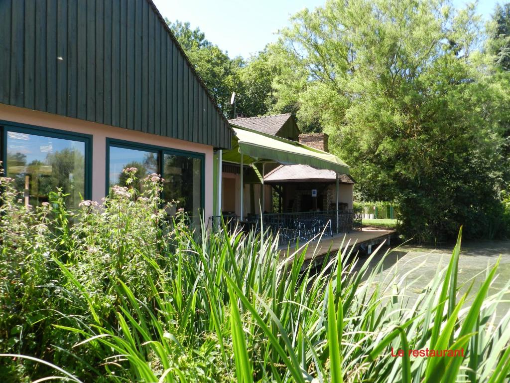 een huis met een tuinhuisje en een aantal planten bij B&B Le Danica in Dordives