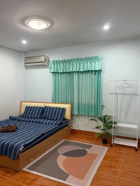 a bedroom with a bed and a green curtain at The Warm House in Ban Komo Sip Paet