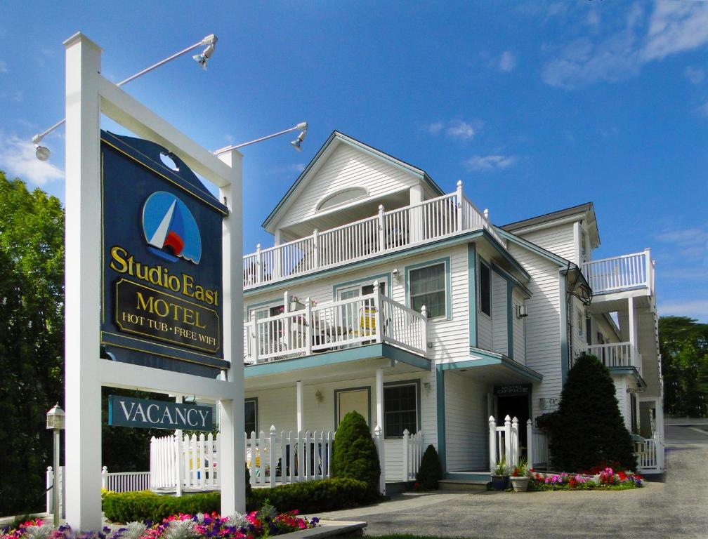 a white house with a sign in front of it at Studio East Motel in Ogunquit