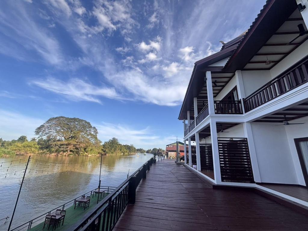 a building on a dock next to a river at Paradise resort, Don Det river view in Don Det