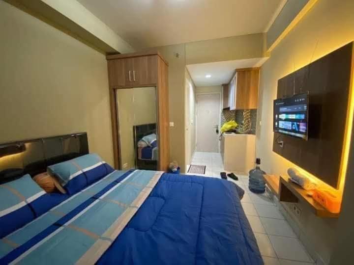 a bedroom with a large blue bed and a tv at Asikin Room in Bulanbulan