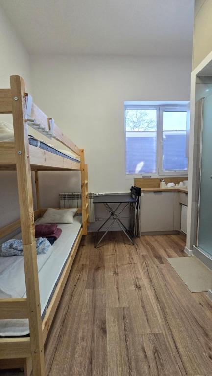 een kamer met twee stapelbedden en een bureau bij Mini nocleg przy dworcu in Tomaszów Mazowiecki