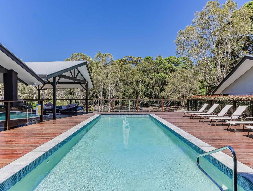 een zwembad met een terras en ligstoelen bij Lennox Coastal Retreat - resort-style home w. pool in Lennox Head