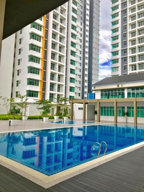 a swimming pool in front of some tall buildings at Prima Resident Meru Ipoh in Ipoh