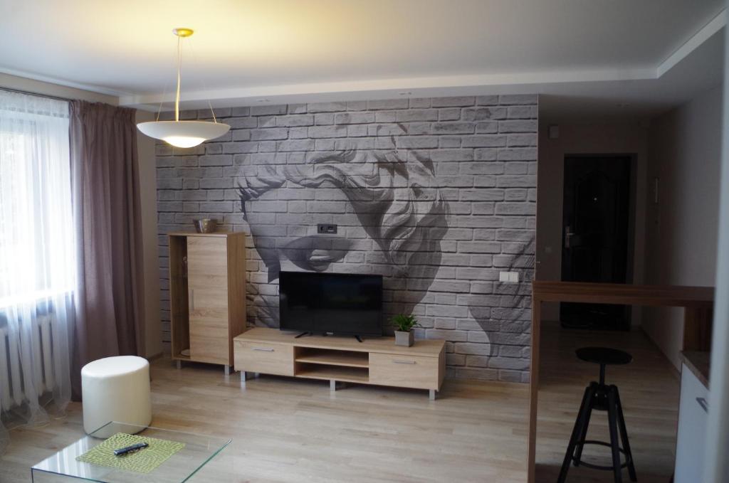 a living room with a mural of a horse on a brick wall at Jaukus butas Klaipėdos centre in Klaipėda