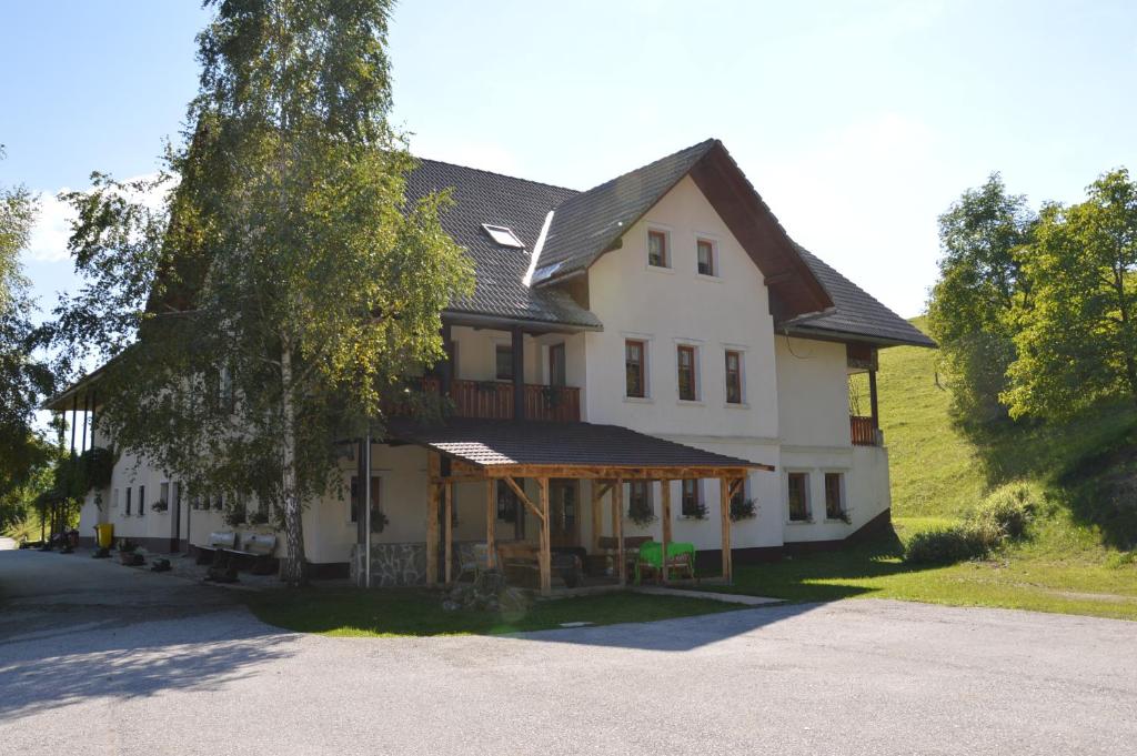 a large white house with a gambrel roof at Apartmens and Rooms Šoštar in Cerkno