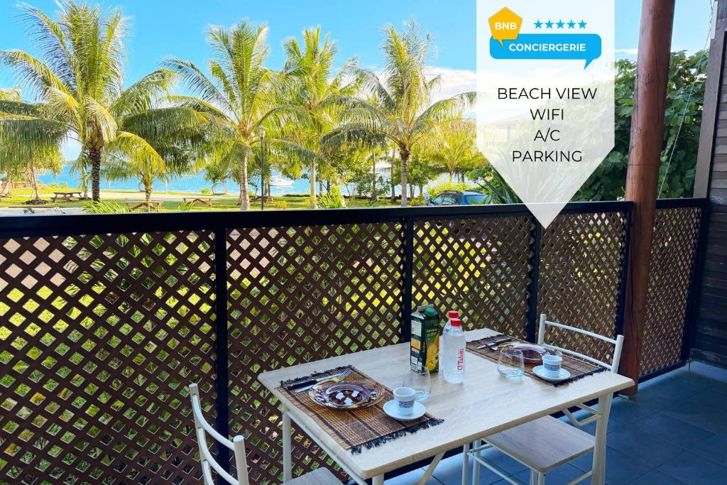 een tafel op een balkon met een bordje waarop staat: uitzicht op het strand met parkeergelegenheid bij Charming beachfront studio in Bora Bora