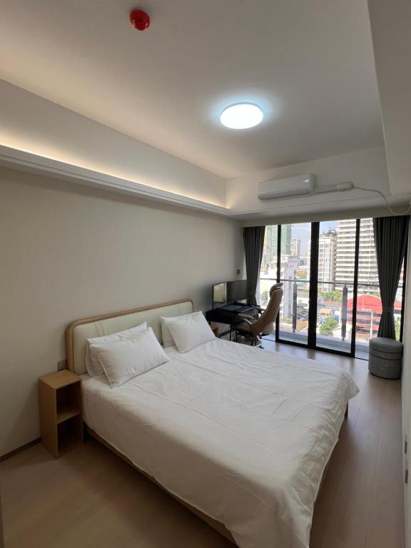 una camera da letto con un grande letto bianco e una scrivania di LeConde Luxury a Phnom Penh