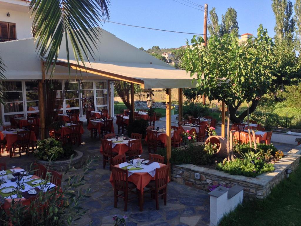a restaurant with tables and chairs in a courtyard at Vontzos Hotel in Achladies