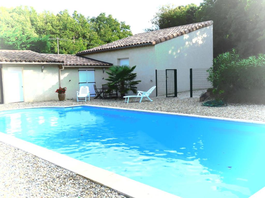 een groot blauw zwembad voor een huis bij La petite maison in Malataverne