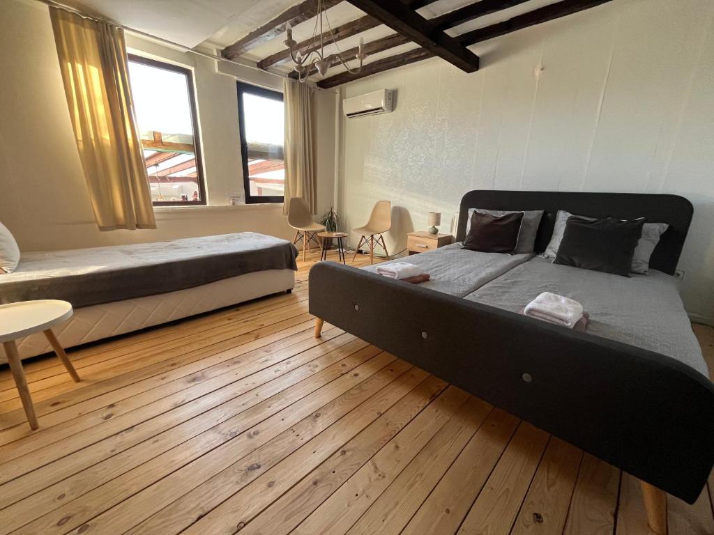 a bedroom with two beds and a wooden floor at Къща Христини in Kalofer