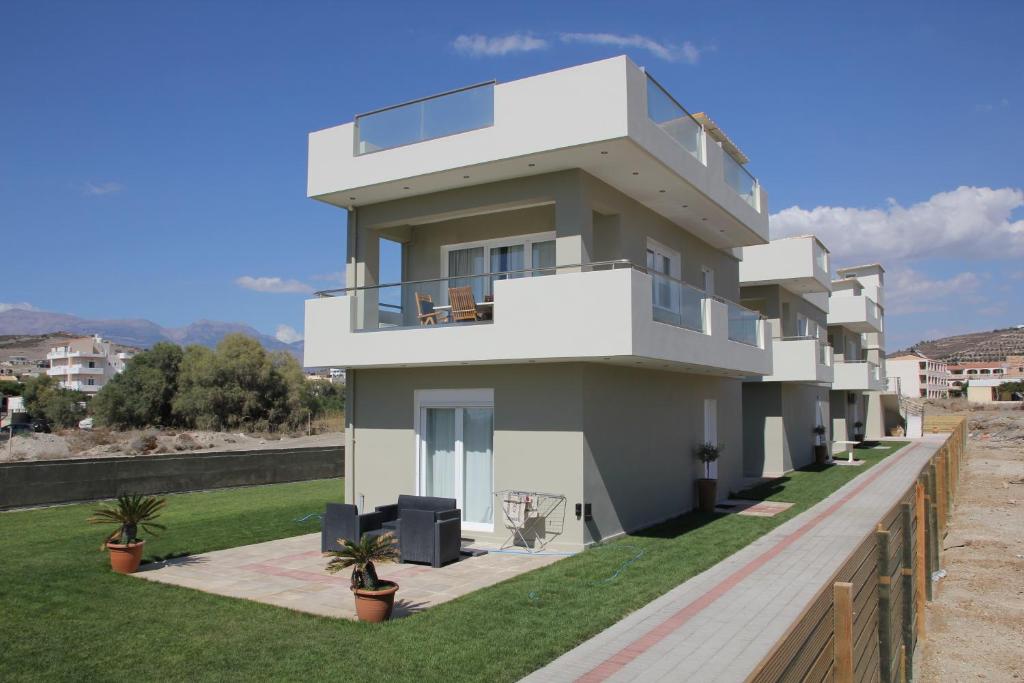 ein großes weißes Haus mit grünem Rasen in der Unterkunft Holiday Luxury Villas in Kalamaki