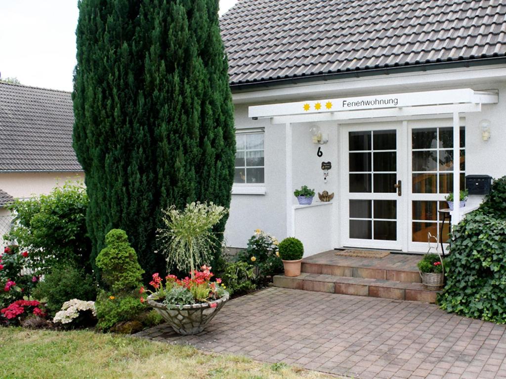 ein Haus mit einem großen Baum davor in der Unterkunft Ferienwohnung Kramer in Rüber