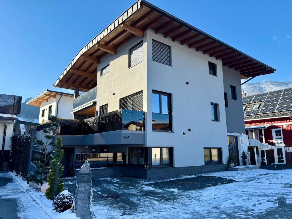 a large white building with snow on the ground at Appartement Krismer in Fügen