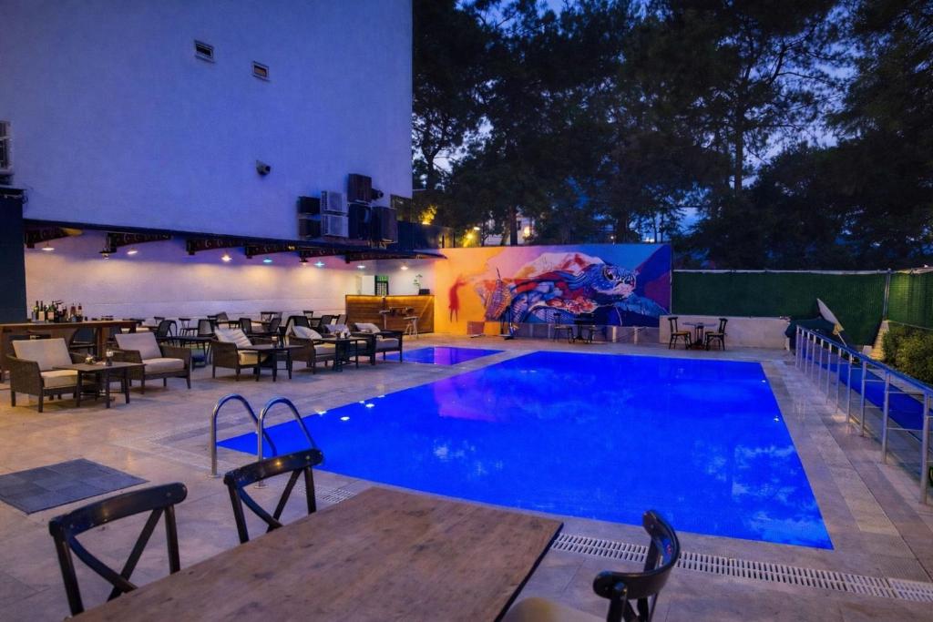 a swimming pool with tables and chairs next to a restaurant at Grand Lavin Hotel in Antalya