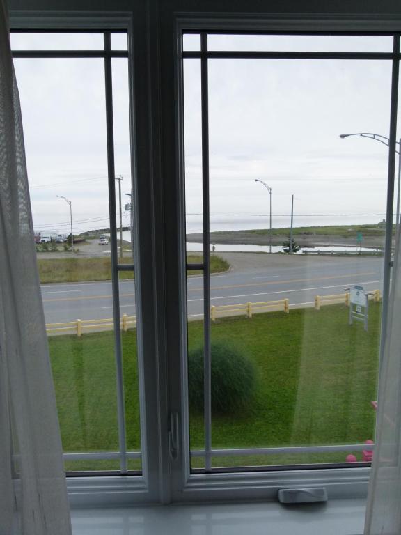 an open window with a view of a highway at La Maison entre Mer Montagnes in Cap-Chat