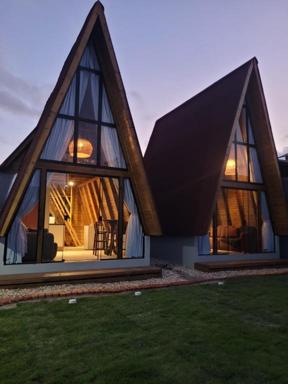 a house with a triangular roof with windows at Hospedagem Chalés Prosas e Versos in Penha