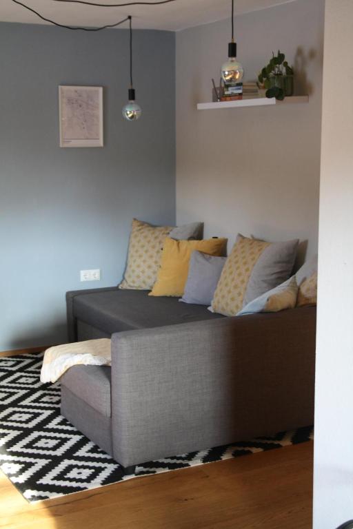 a couch with pillows on it in a living room at haus nummer fünf - inklusive Chiemgau Karte in Siegsdorf