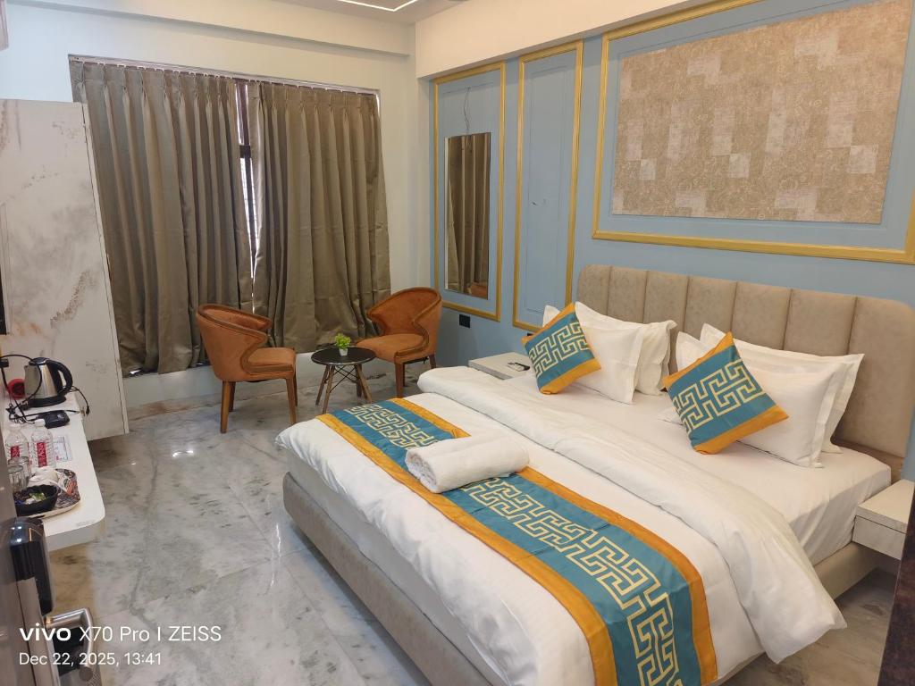 a hotel room with two beds and a table and chairs at KDM Hotel Indore Palace- a walk away from Saibaba Temple in Shirdi