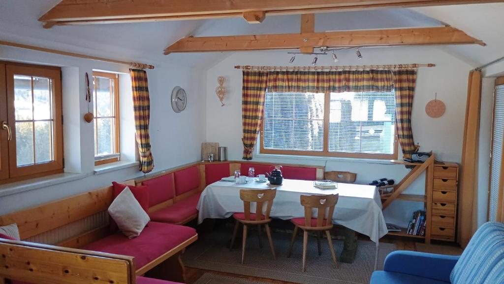 a dining room with a table and a red couch at Ferienwohnung Gräßl - Almzeit in Preitenegg
