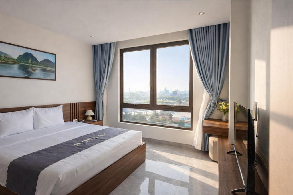 a bedroom with a large bed and large windows at The Sun Hotel Pho Co Ninh Binh in Ninh Binh