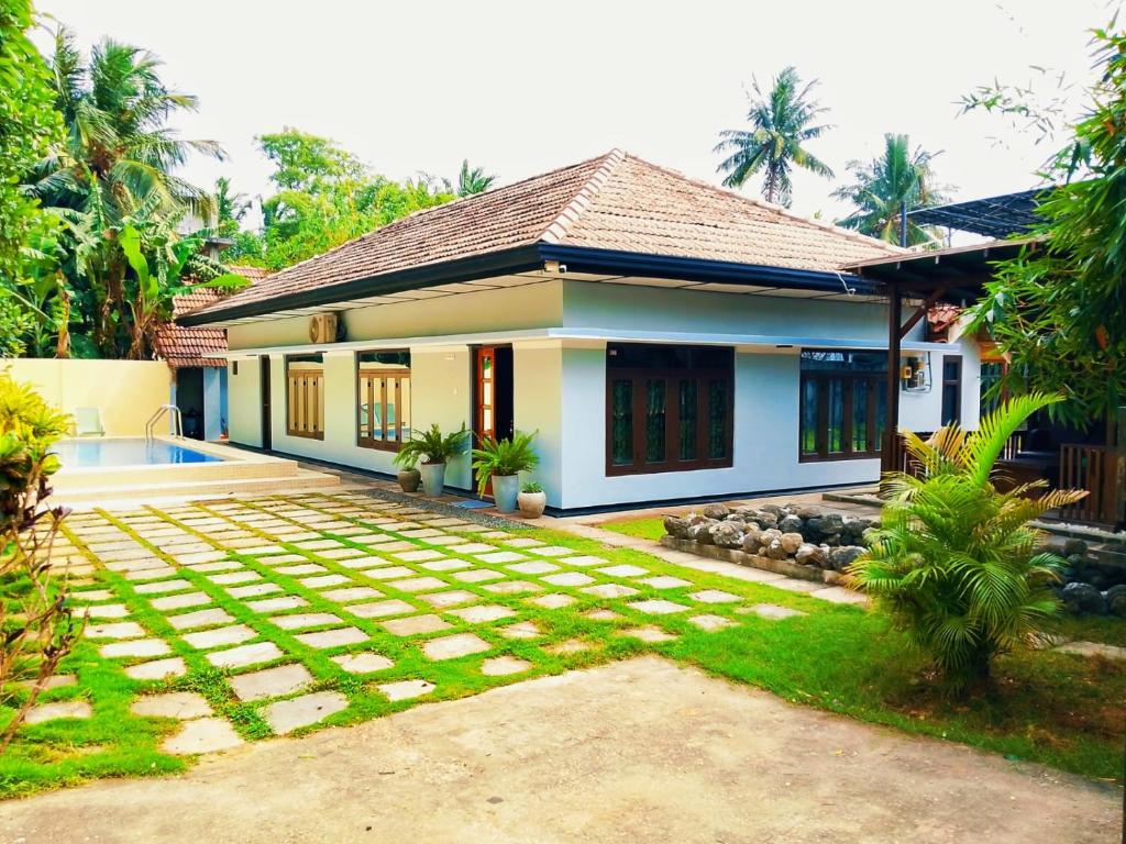 贾夫纳Abbi Holidays - Entire Private Villa with Swimming Pool - jaffna town的一栋前面带花园的房子