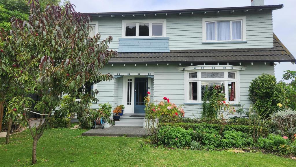 a white house with a blue door and a yard at La Casa in Napier