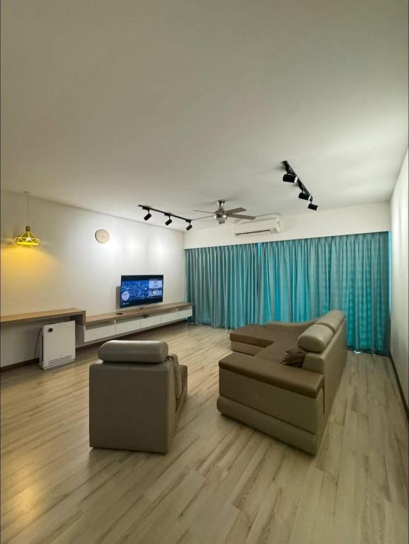a living room with couches and a flat screen tv at SDC Suite Home 6 in Lahad Datu