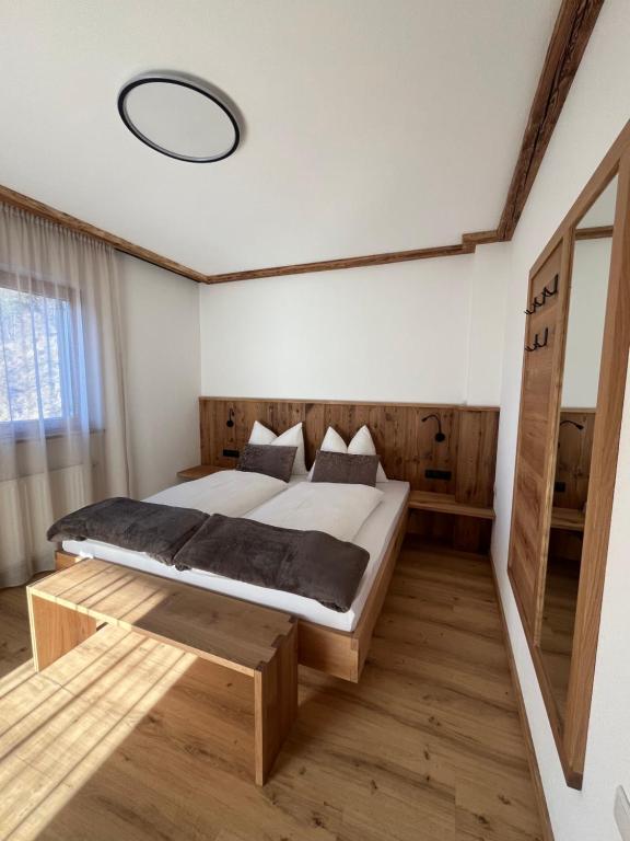 a bedroom with a large bed and a mirror at Mountain River Apartment in Chienes