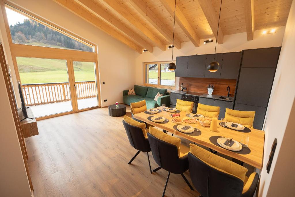 een eetkamer en keuken met een tafel en stoelen bij dein Dahoam Boutique Appartements in Gröbming