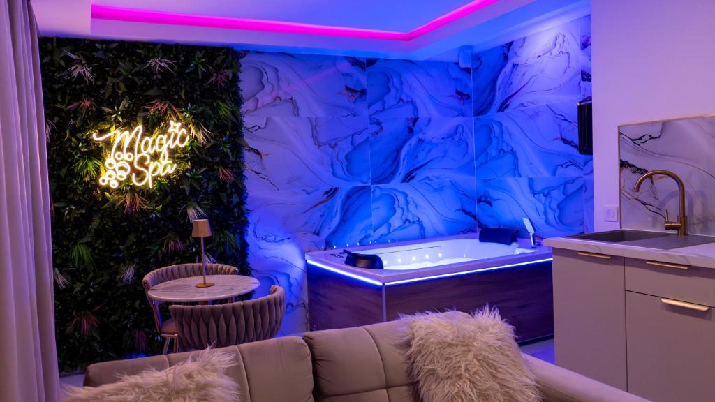 a blue room with a couch and a sink at MagicSpa Gold in Chilly-Mazarin