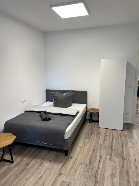 een slaapkamer met een bed en een houten vloer bij Check In by BeOne in Villingen-Schwenningen