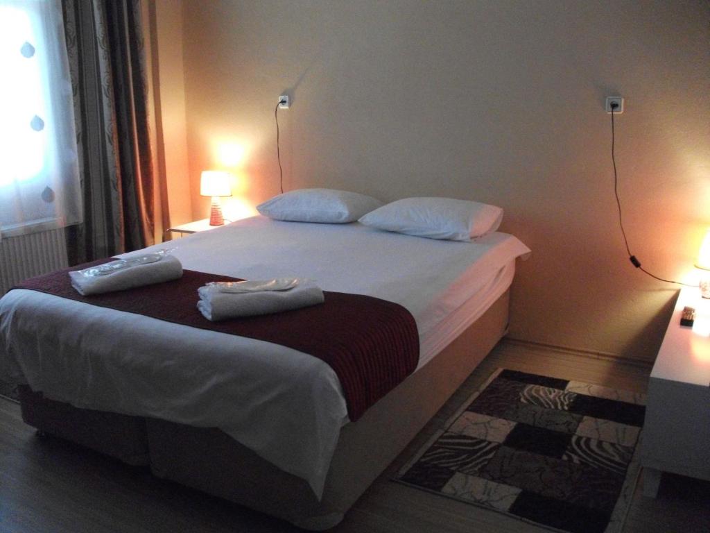1 dormitorio con 1 cama con 2 toallas en Ernur Pension en Çanakkale