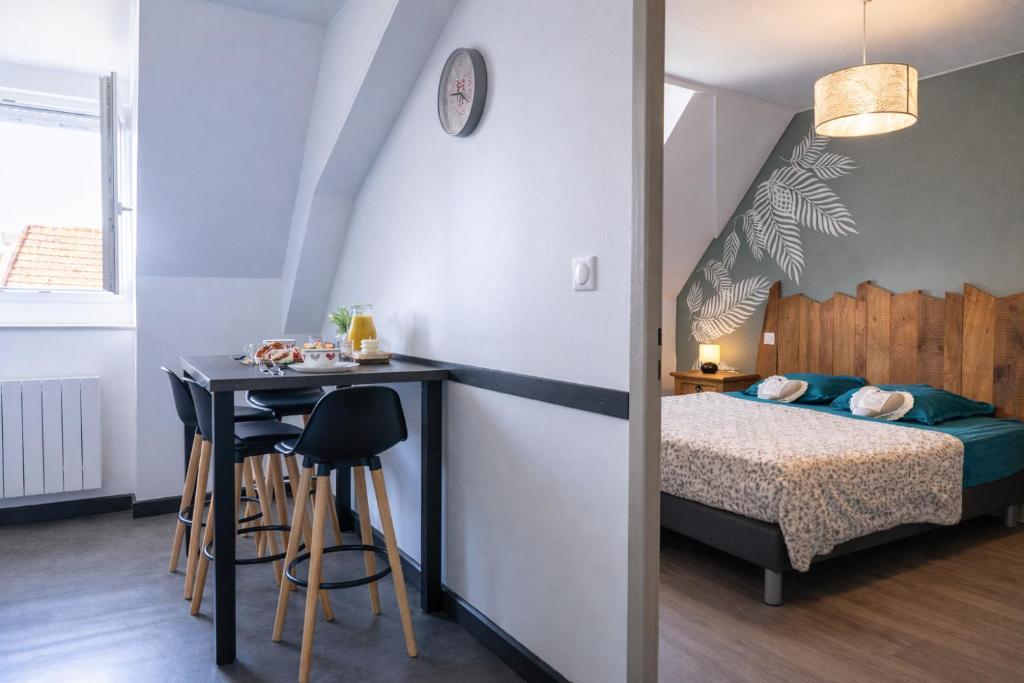 een slaapkamer met een bed, een tafel en een bureau bij Appartement cosy centre historique in Thann